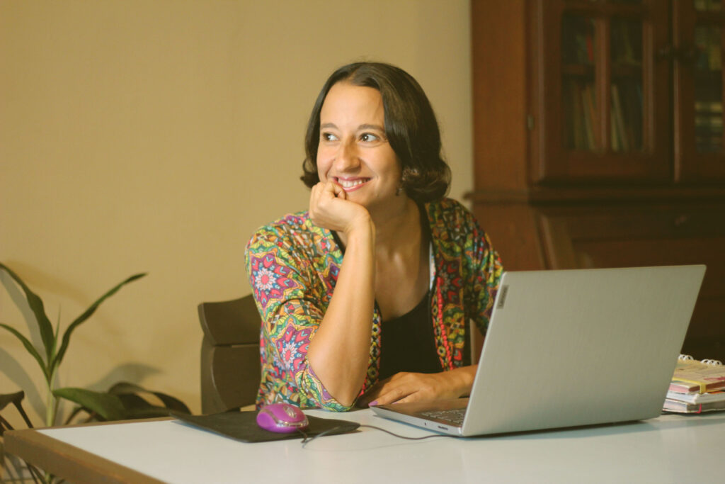 Persona sentada frente a la computadora, mirando al horizonte con una expresión feliz y reflexiva, inspirada en el liderazgo Persona sentada frente a la computadora, mirando al horizonte con una expresión feliz y reflexiva, inspirada en el liderazgo